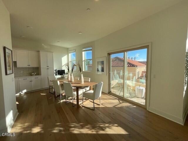 dining area featuring baseboards, wood finished floors, and a healthy amount of sunlight