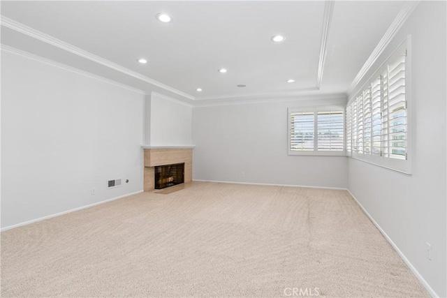 unfurnished living room with light carpet, a raised ceiling, ornamental molding, and a fireplace