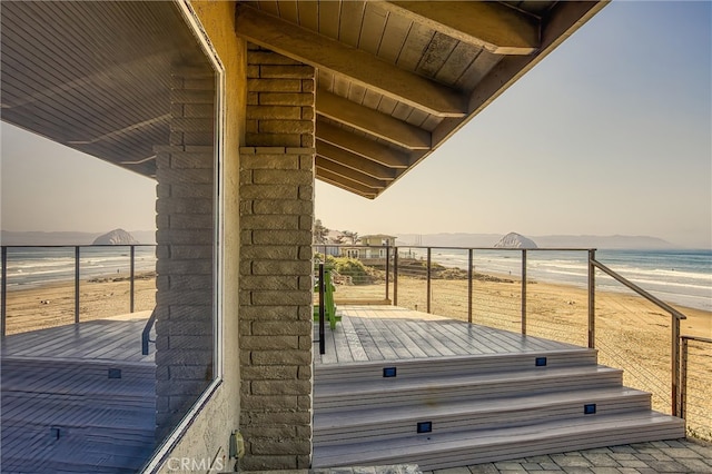 deck at dusk featuring a water view