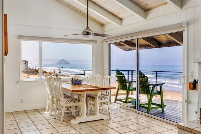 tiled dining space featuring lofted ceiling with beams, wood ceiling, a view of the beach, a water view, and ceiling fan