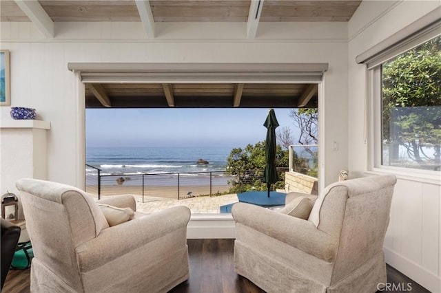 living room featuring beam ceiling, a water view, and dark hardwood / wood-style floors