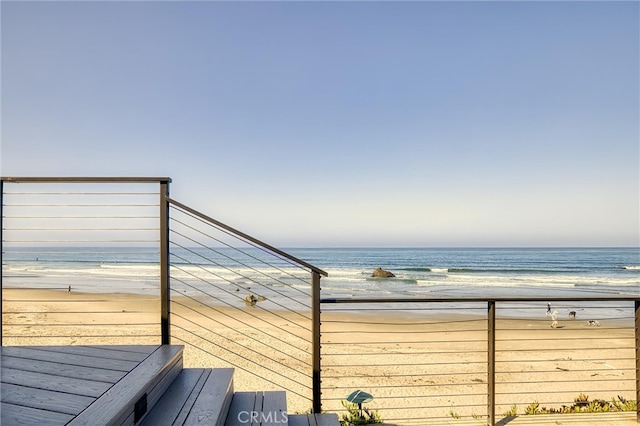 deck with a beach view and a water view