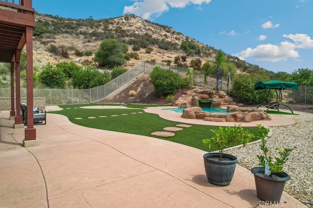 surrounding community with a patio and a mountain view