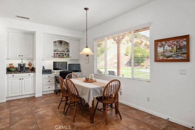 dining area featuring dark tile patterned flooring