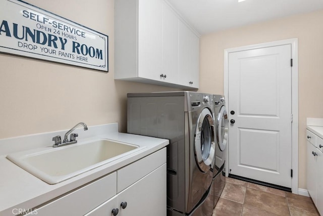 laundry area with sink, tile patterned flooring, washer and dryer, and cabinets