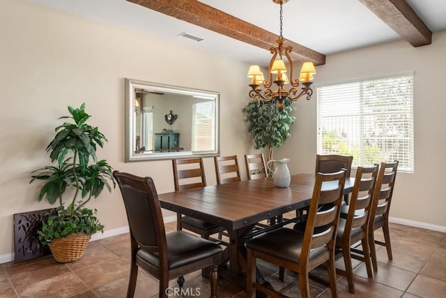 dining space featuring beam ceiling, dark tile patterned floors, and a chandelier