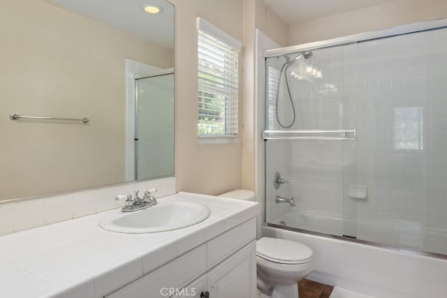 full bathroom featuring toilet, vanity, and combined bath / shower with glass door