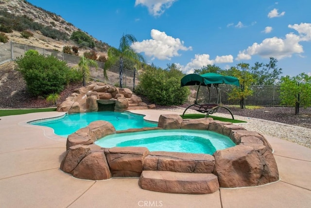 view of pool with an in ground hot tub and a mountain view