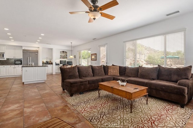 tiled living room featuring ceiling fan