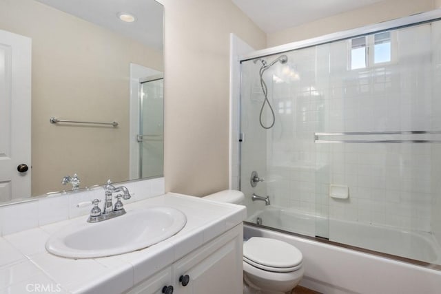 full bathroom with toilet, vanity, and shower / bath combination with glass door