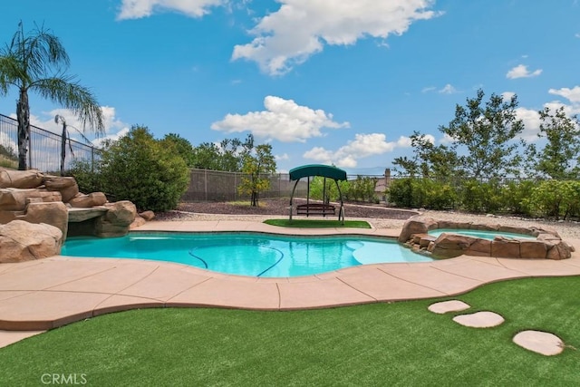 view of swimming pool with a yard and an in ground hot tub