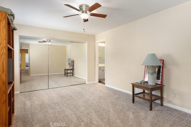 bedroom with ceiling fan, light colored carpet, connected bathroom, and a closet