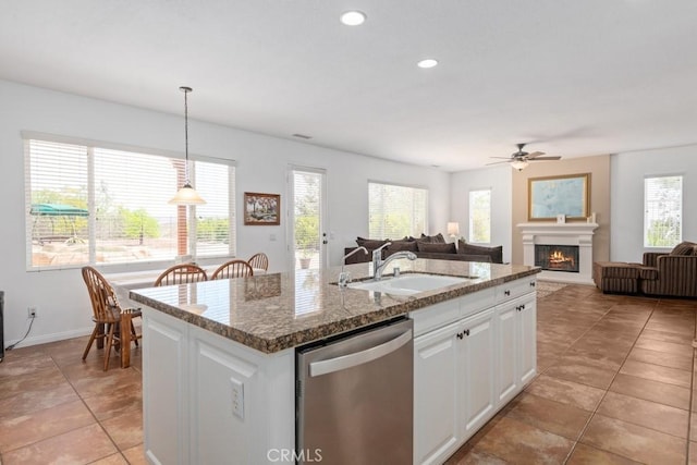 kitchen featuring stainless steel dishwasher, pendant lighting, a center island with sink, white cabinets, and sink