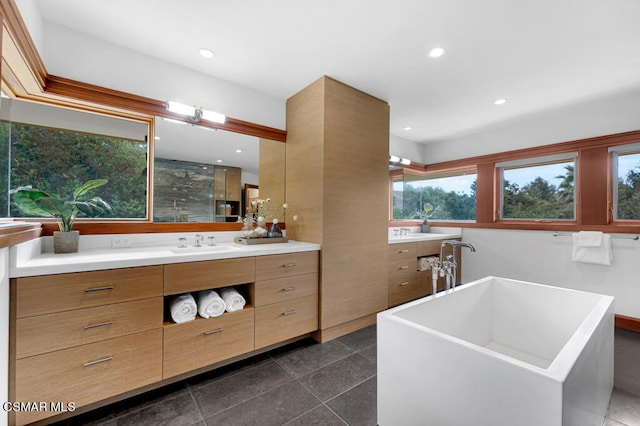 bathroom featuring vanity, a bathtub, and tile patterned floors