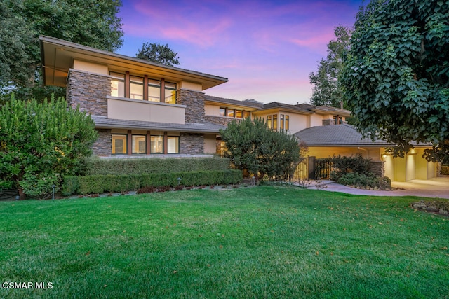 prairie-style house featuring a yard and a balcony