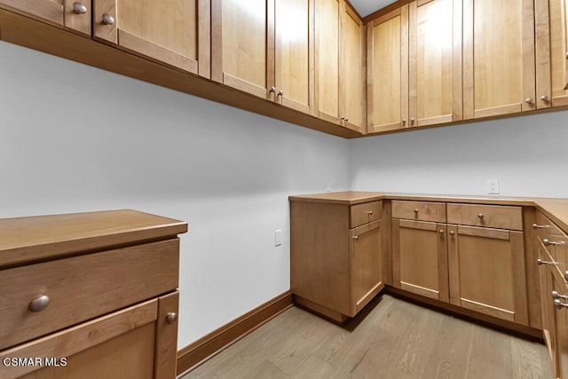 clothes washing area with light hardwood / wood-style floors