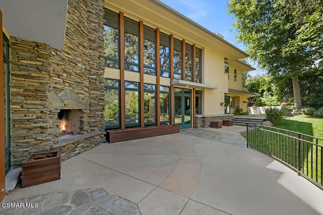 view of patio / terrace featuring an outdoor stone fireplace