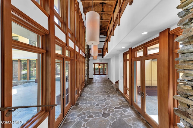 hallway featuring a towering ceiling and french doors