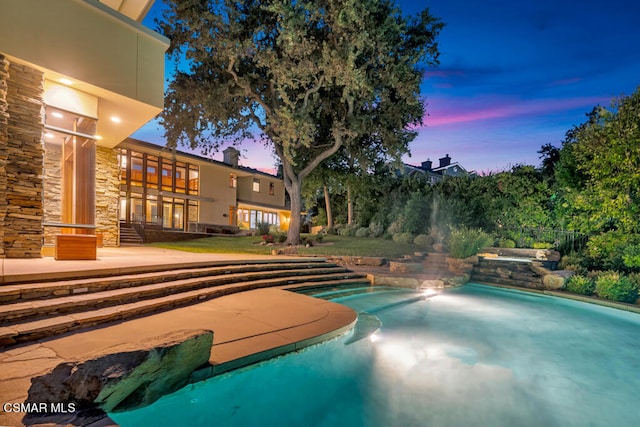 pool at dusk with a patio