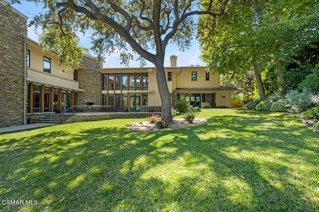 rear view of house featuring a patio, french doors, and a lawn