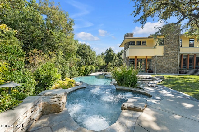 view of pool with an in ground hot tub, a patio area, and french doors