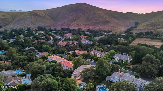 aerial view at dusk featuring a mountain view