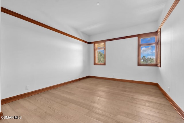 empty room with light hardwood / wood-style flooring and ornamental molding