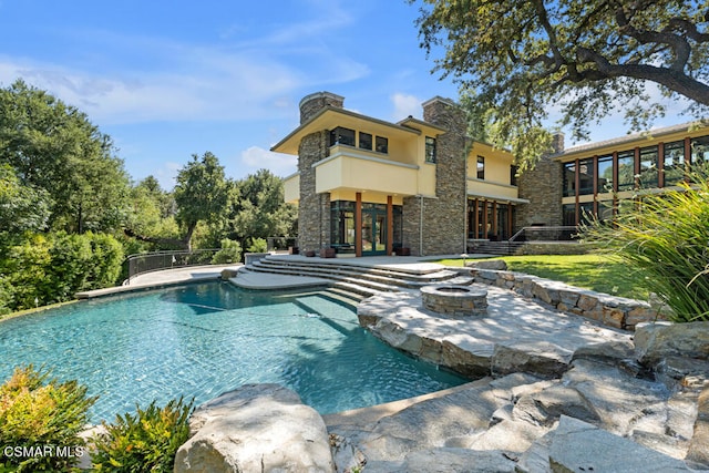 view of pool featuring french doors, a patio area, and a fire pit