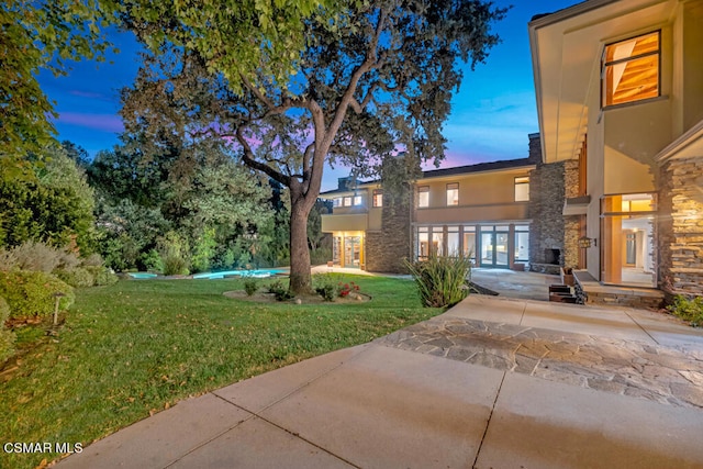 view of front of property featuring a patio and a lawn