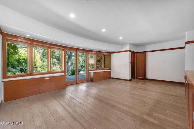 unfurnished living room with light hardwood / wood-style floors and french doors