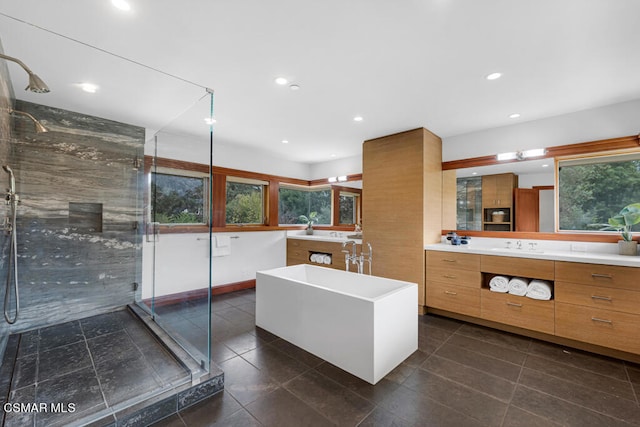 bathroom with vanity and shower with separate bathtub