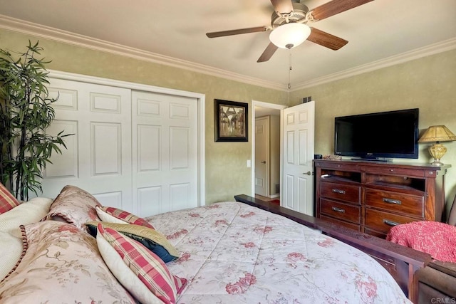 bedroom featuring hardwood / wood-style flooring, ceiling fan, ornamental molding, and a closet