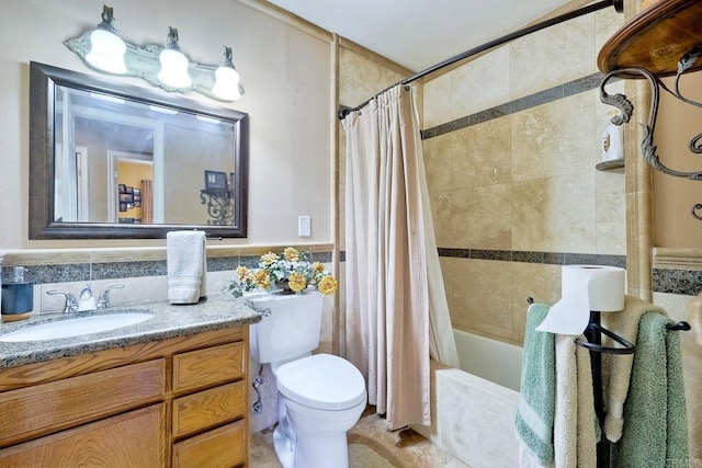 full bathroom with shower / tub combo with curtain, vanity, toilet, and tile walls