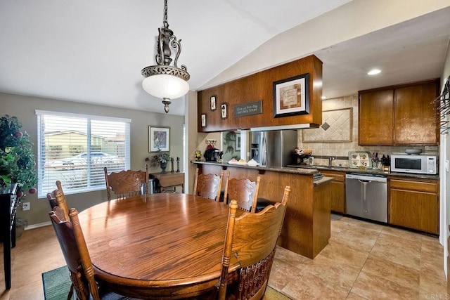 dining space with light tile patterned floors and vaulted ceiling