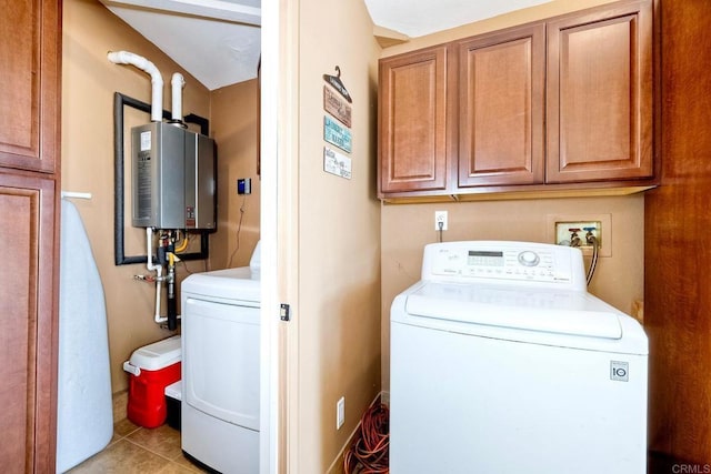 laundry area with cabinets, tankless water heater, washing machine and clothes dryer, and light tile patterned floors