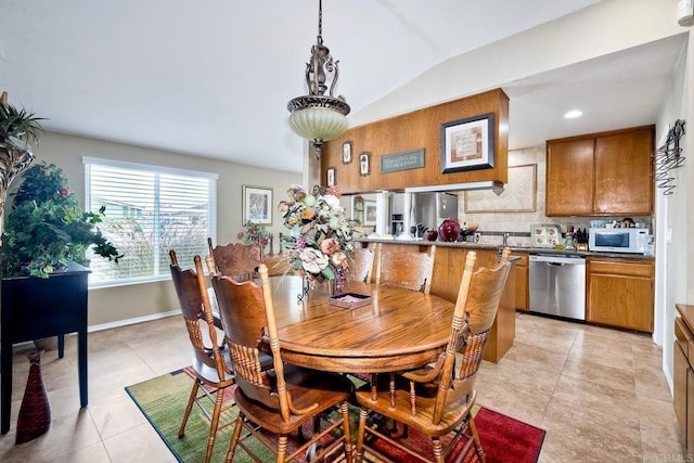 tiled dining space featuring lofted ceiling