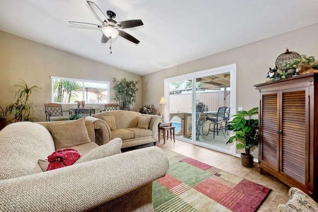 living room featuring vaulted ceiling, light tile patterned flooring, and ceiling fan