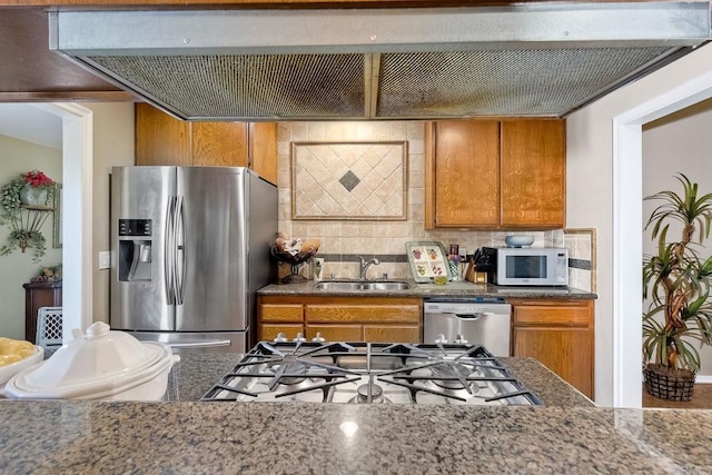 kitchen with tasteful backsplash, extractor fan, appliances with stainless steel finishes, and sink