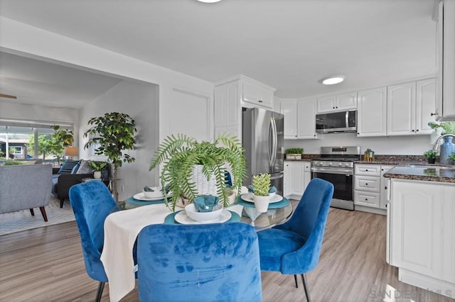 kitchen featuring light hardwood / wood-style flooring, white cabinetry, appliances with stainless steel finishes, and sink