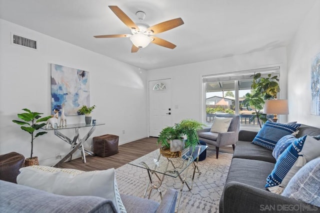 living room featuring wood-type flooring and ceiling fan