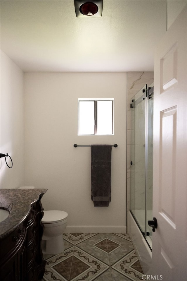 full bathroom featuring shower / bath combination with glass door, vanity, tile patterned flooring, and toilet