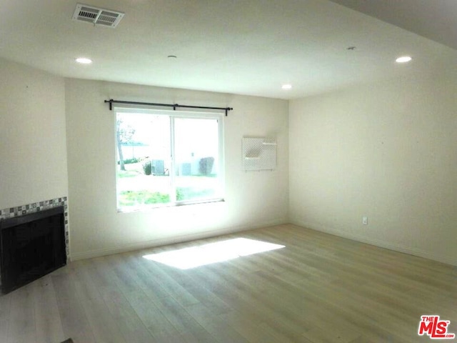 unfurnished living room featuring light hardwood / wood-style floors and a fireplace