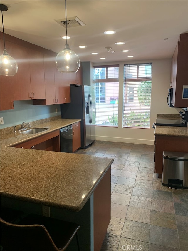 kitchen with pendant lighting, stainless steel appliances, kitchen peninsula, and sink