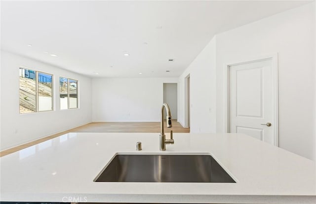 kitchen with open floor plan, an island with sink, a sink, and recessed lighting