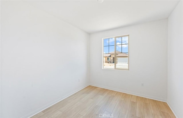 spare room with light wood-style floors and baseboards