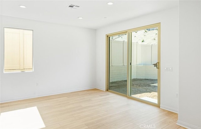 empty room featuring recessed lighting, baseboards, visible vents, and light wood finished floors