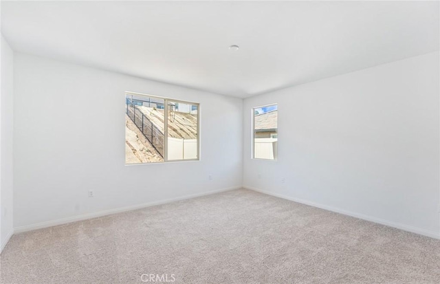 unfurnished room with carpet flooring and baseboards