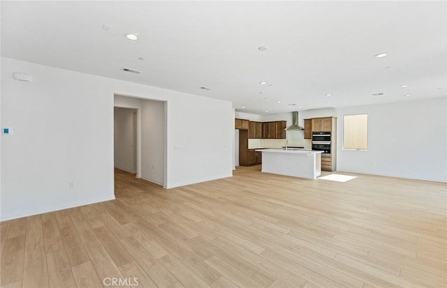 unfurnished living room with light wood-style floors, recessed lighting, visible vents, and baseboards