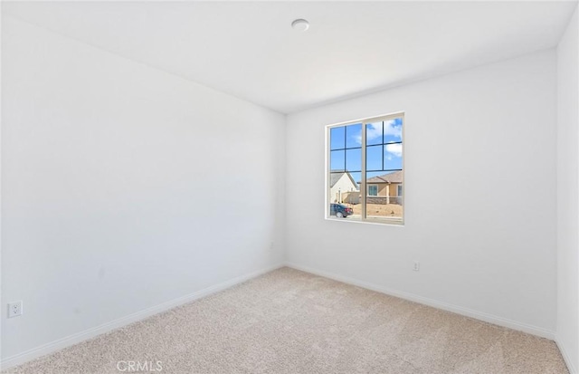 carpeted empty room with baseboards