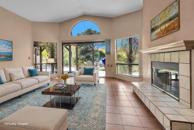 tiled living room with lofted ceiling and a tiled fireplace